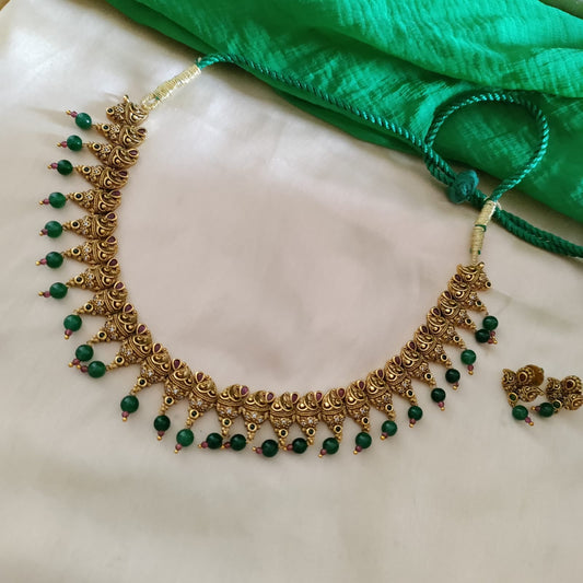 Simple golden necklace with green bead drop