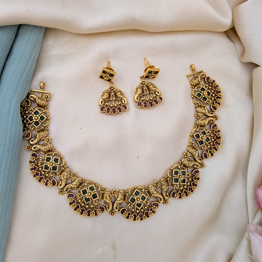 Golden necklace with kemp stones and majestic trunk motif on both sides