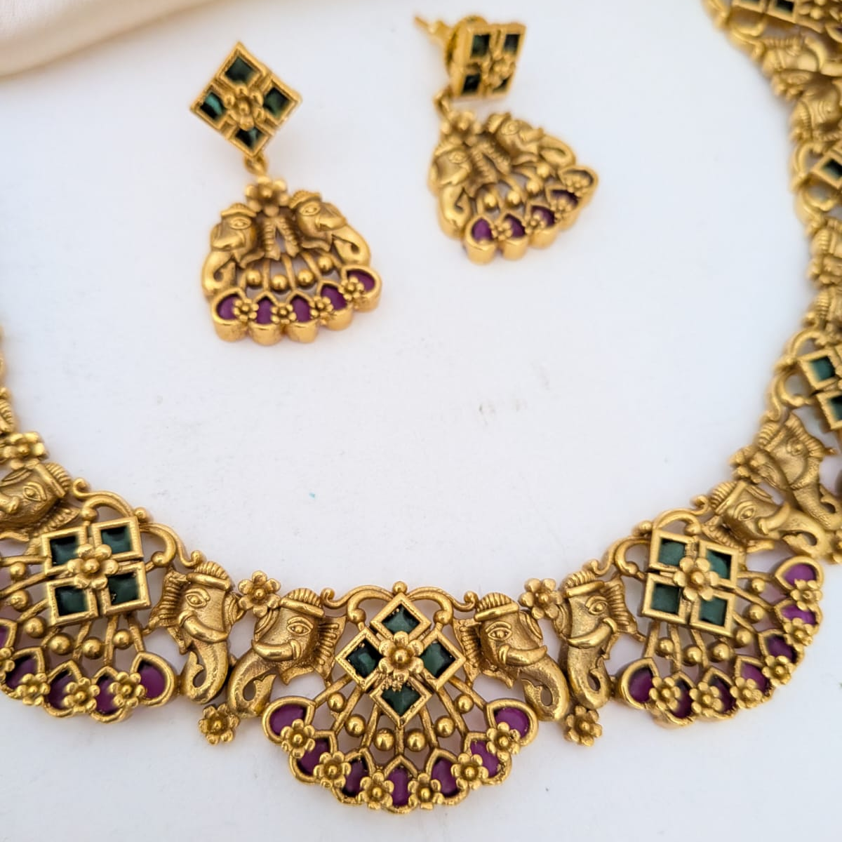 Golden necklace with kemp stones and majestic trunk motif on both sides