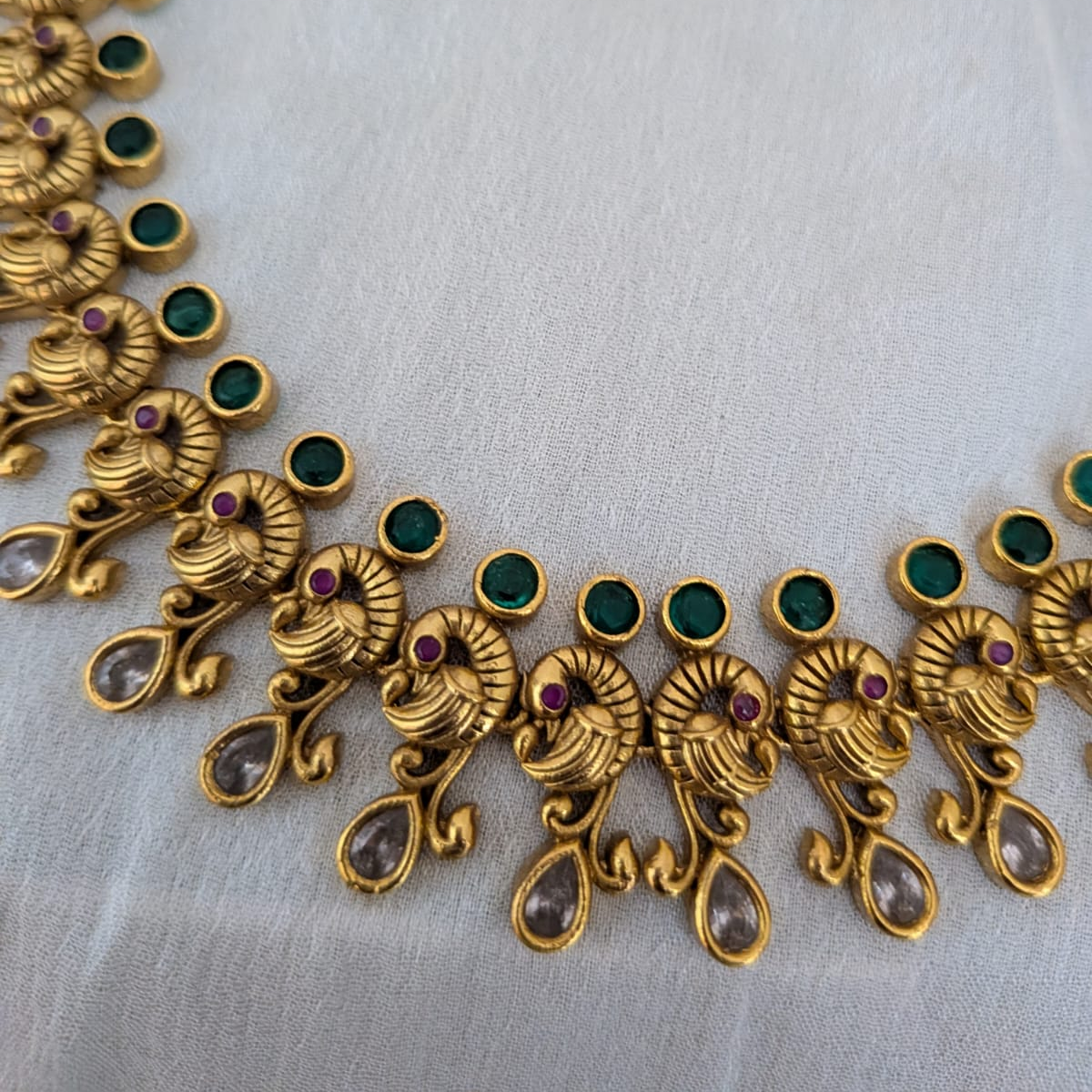 Timeless beauty of peacock paired with emerald stone necklace